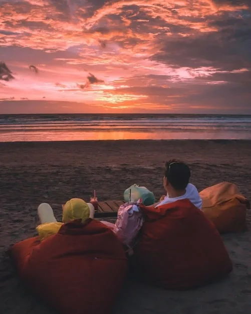 A family enjoying a tropical beach at sunset, symbolizing a relaxed and affordable holiday getaway made possible by flexible travel planning.