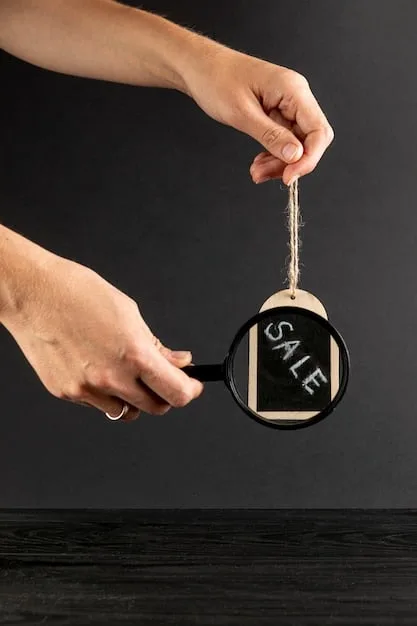 A hand holding a magnifying glass over a price tag that shows both the original price and the discounted price. The background is blurred, emphasizing the scrutiny of the price tag.