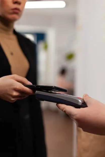 A close-up shot of a store credit card being swiped at a checkout terminal in a clothing store. The focus is on the card and the point-of-sale system.