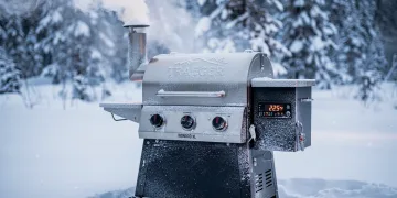 Traeger Ironwood XL pellet grill maintaining 225°F in heavy snow, demonstrating cold weather performance.