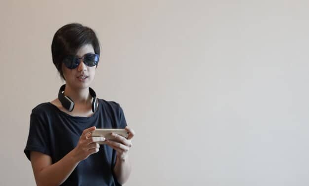 A person wearing AR glasses and using a mobile app to virtually place a piece of furniture in their living room, demonstrating the AR-powered 