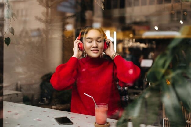 A person wearing noise-canceling headphones in a busy coffee shop. The headphones are white and sleek, and the person is smiling and relaxed. The background is filled with people talking and the sounds of coffee machines.