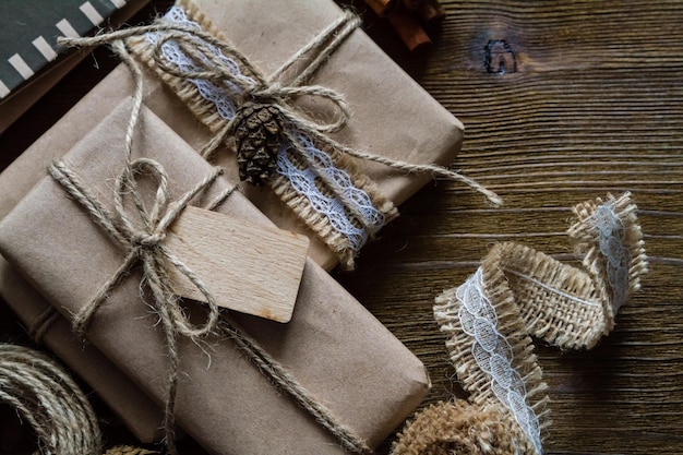 A close-up of beautifully wrapped gifts using recycled materials like newspaper and twine, with handmade gift tags attached.