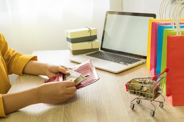 A person writing down their online shopping budget in a notebook, with a laptop open in the background showing an online store.