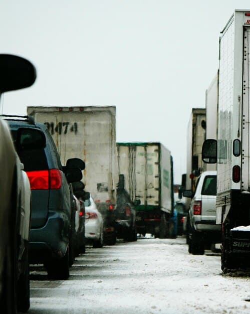 Trucks from FedEx, UPS, and USPS lined up during the holiday season, filled with packages, illustrating the logistical challenges and importance of carrier deadlines.