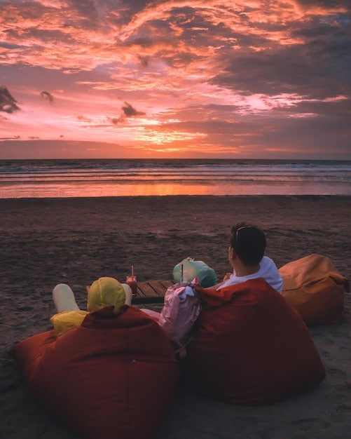 A family enjoying a tropical beach at sunset, symbolizing a relaxed and affordable holiday getaway made possible by flexible travel planning.