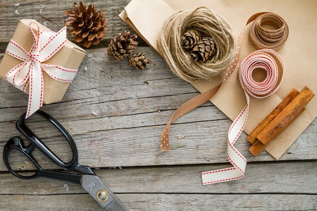 Close-up of various DIY bows made from different materials such as ribbon, twine, and paper. The bows are neatly arranged on a craft table, showcasing different styles and techniques. The focus is on the textures and details of each bow.