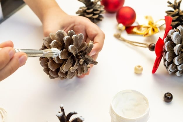 A close-up shot of hands crafting holiday ornaments made from recycled materials such as paper, fabric scraps, and pinecones, on a wooden table with crafting supplies scattered around.